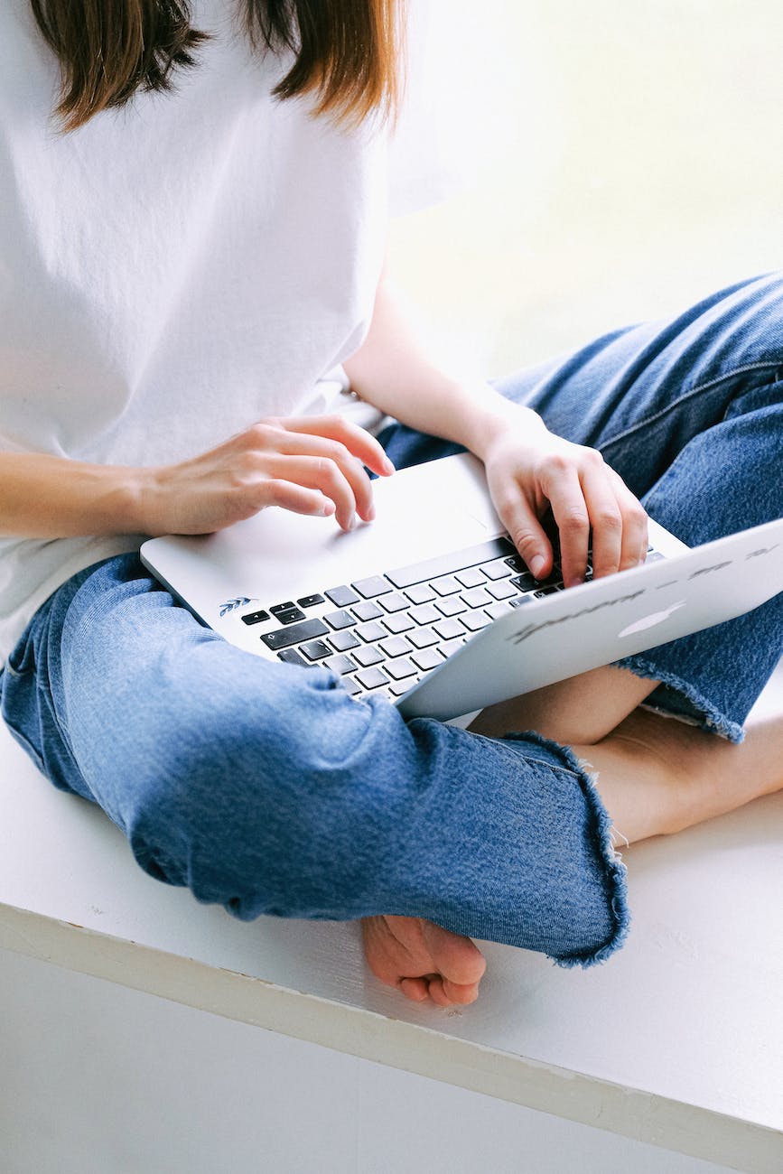 person in blue denim jeans using macbook